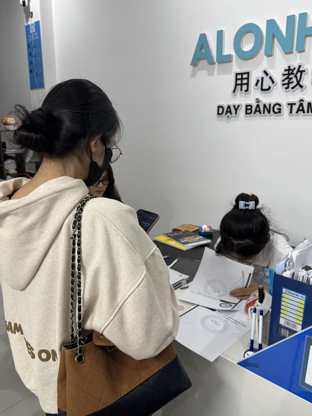 Quầy đón tiếp Alonhi Chinese với biển hiệu Dạy Bằng Tâm - Học Một Hiểu Mười
